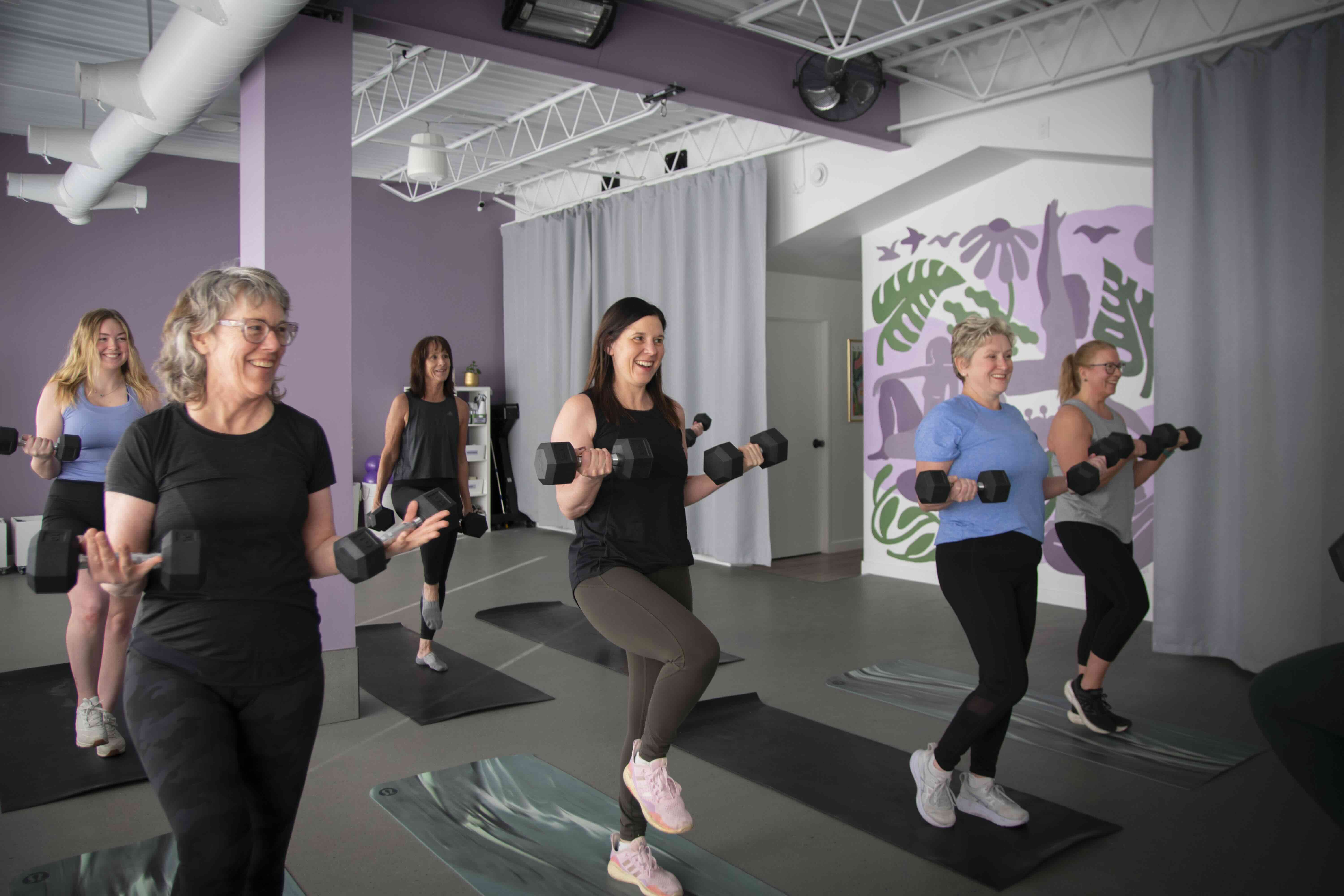 Women doing standing cardio rotations in class
